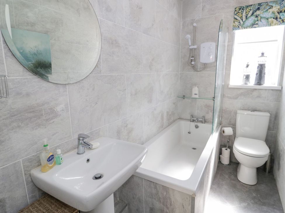 A bathroom with a sink bathtub and toilet at Branwen in Talacre