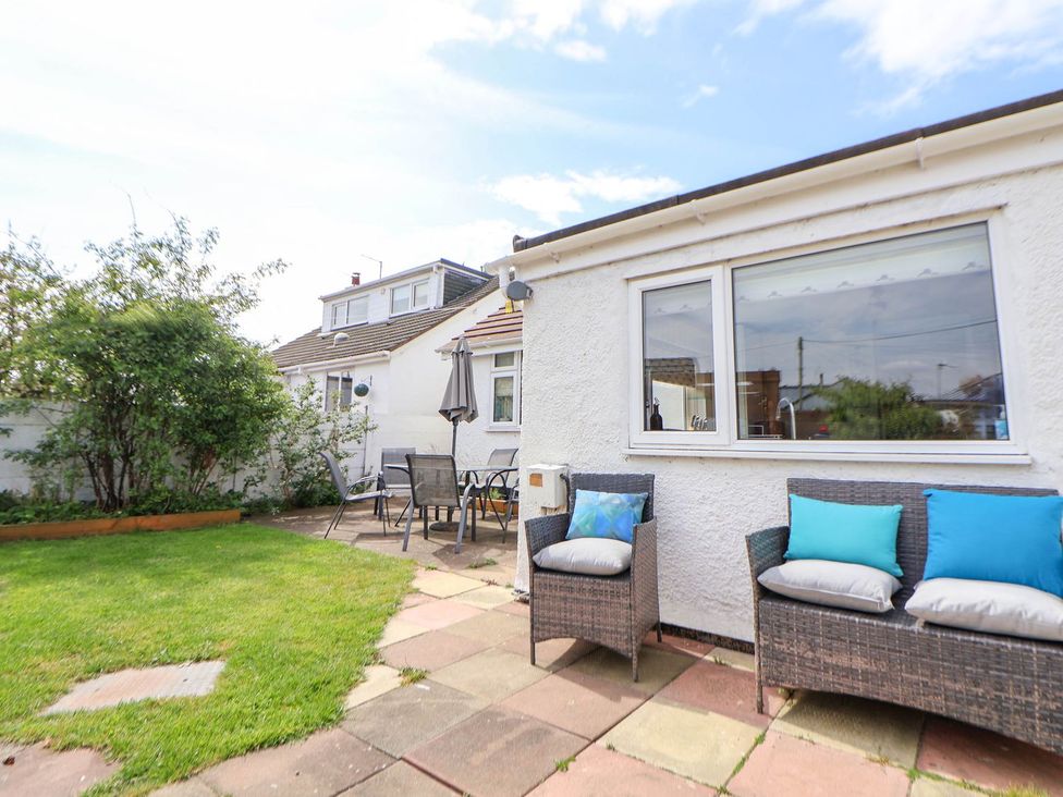 A garden with furniture and a house at Branwen in Talacre