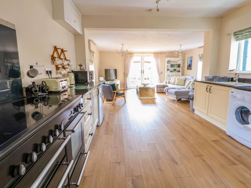 A kitchen with various appliances and a living area at Brimrod Talacre