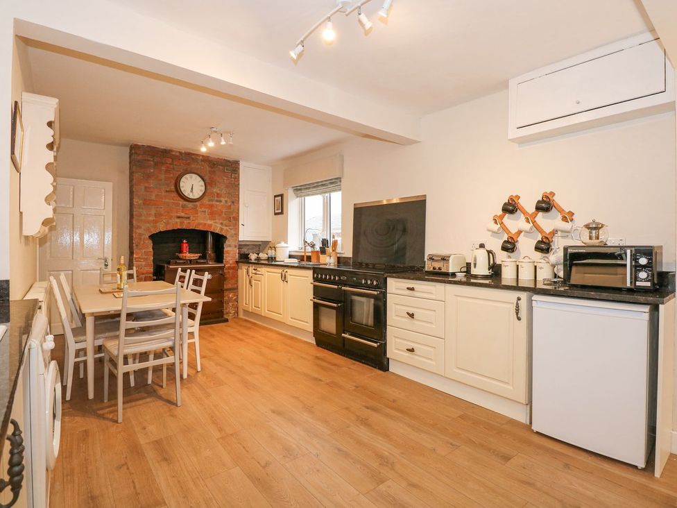 A kitchen with wooden flooring and appliances at Brimrod Talacre