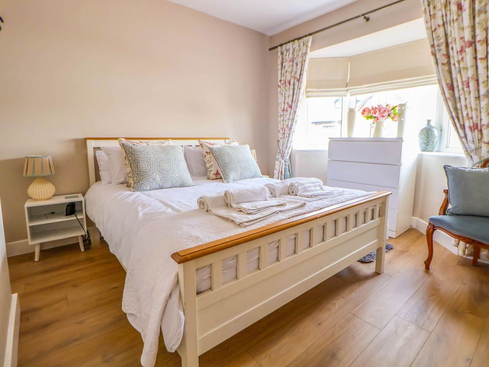 A bedroom with a bed and floral curtains at Brimrod in Talacre