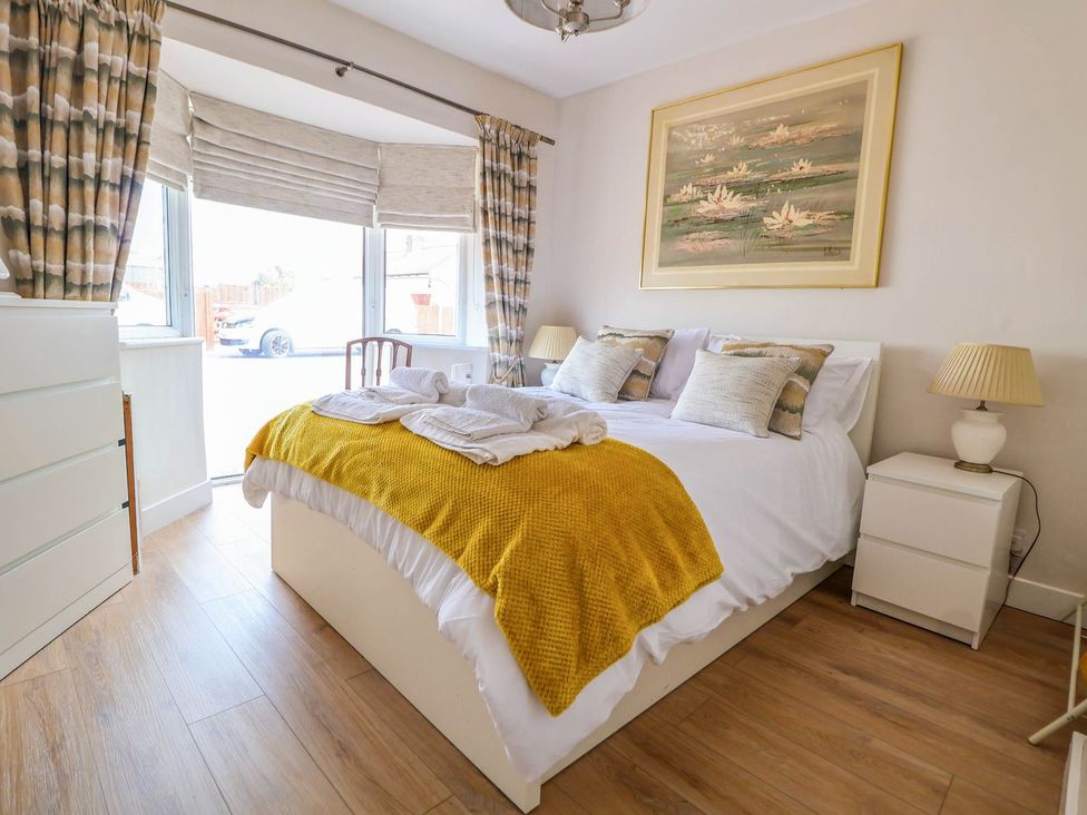 A bedroom with a bed and dresser at Brimrod in Talacre