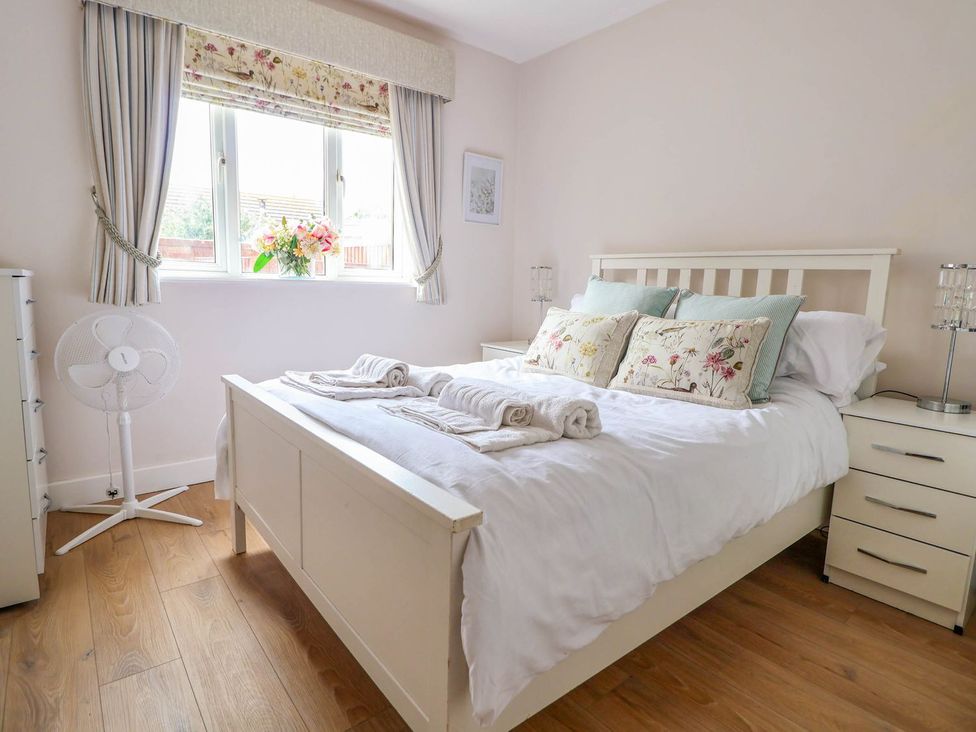 A bedroom with a bed and bedside table at Brimrod in Talacre