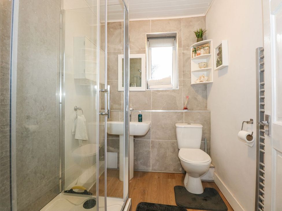 A bathroom with a shower, toilet, and sink at Brimrod in Talacre