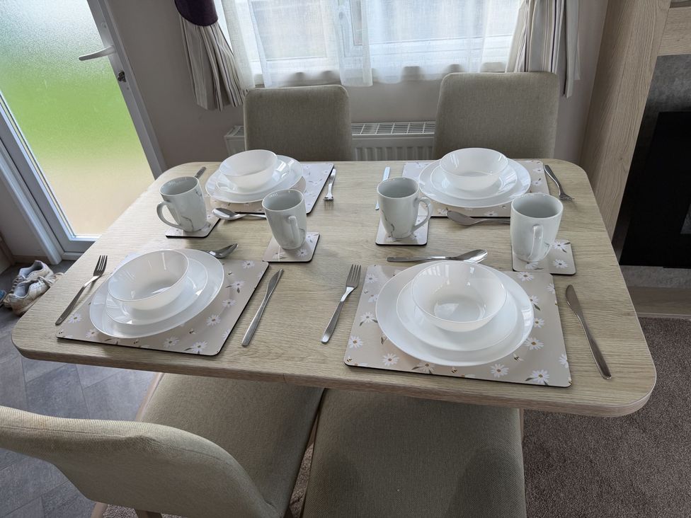 A dining table set with plates and cups at Coastfields Holiday Village Skegness