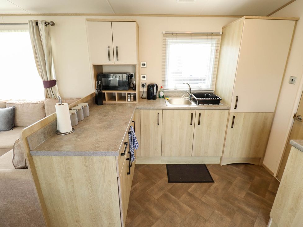 A kitchen with cabinets and appliances at Coastfields Holiday Village in Ingoldmells