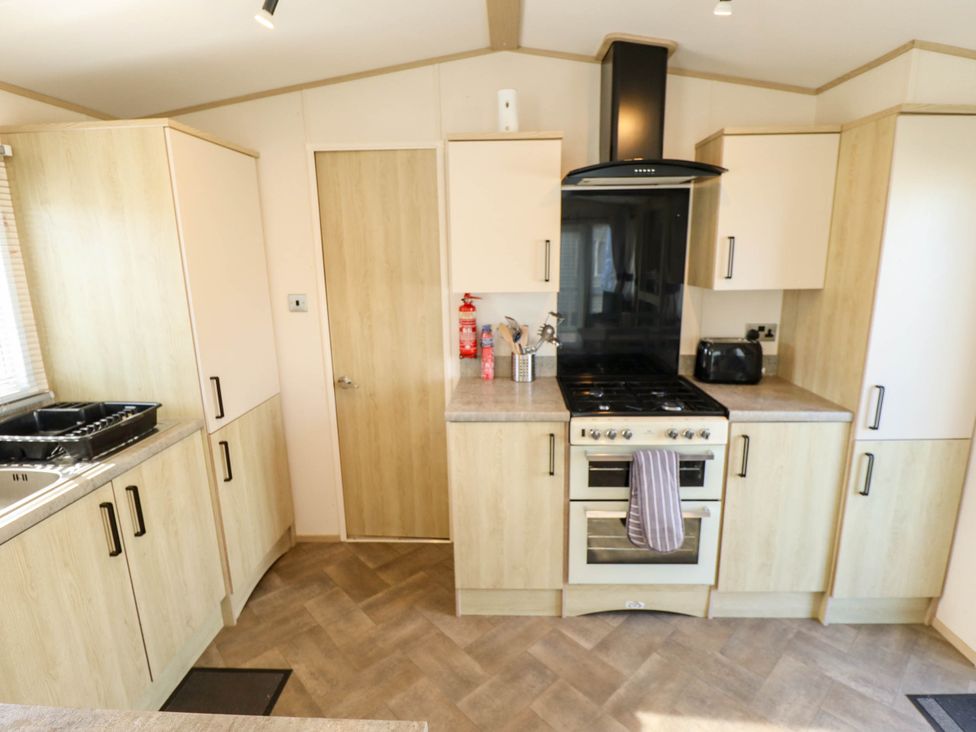 A kitchen with cabinets and appliances at Coastfields Holiday Village Ingoldmells