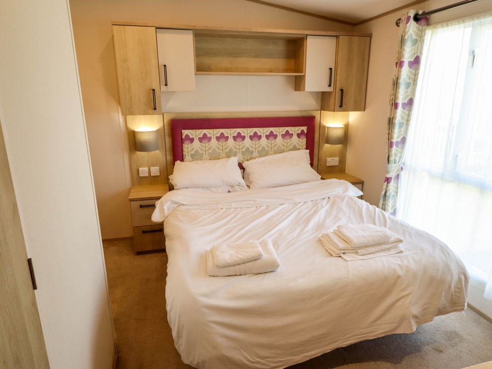 A bedroom with a bed and bedside tables at Coastfields Holiday Village Ingoldmells