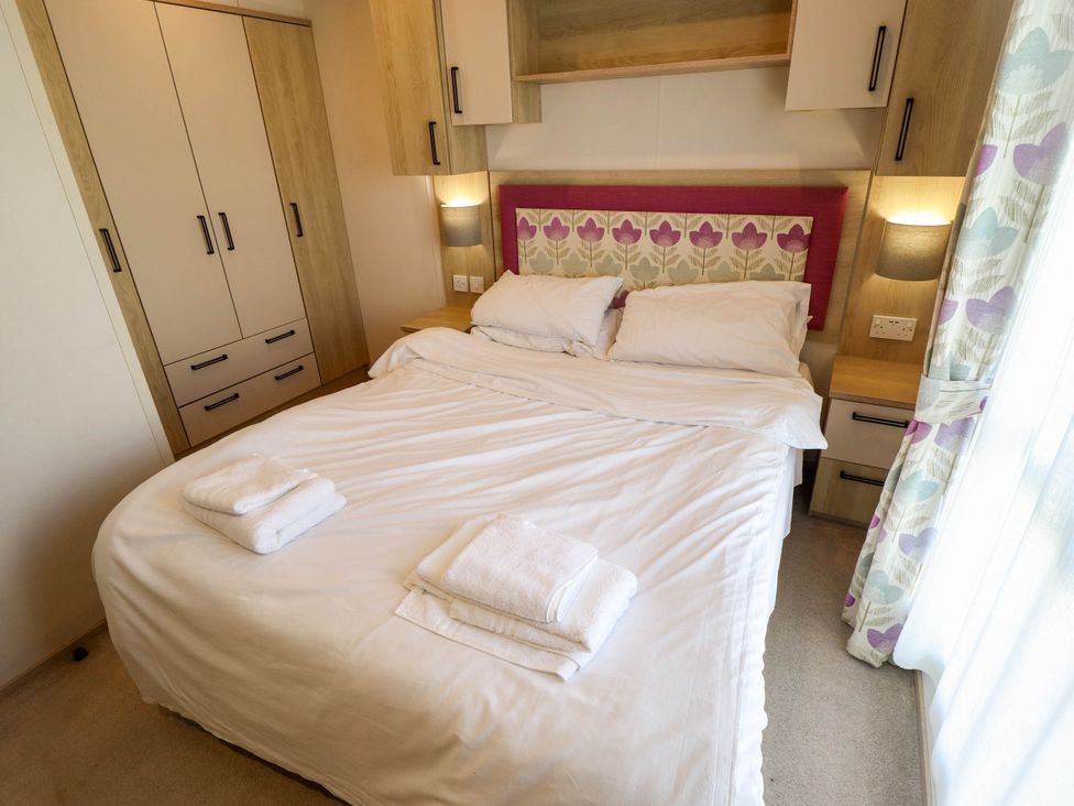 A bedroom with a double bed and wardrobe at Coastfields Holiday Village Ingoldmells