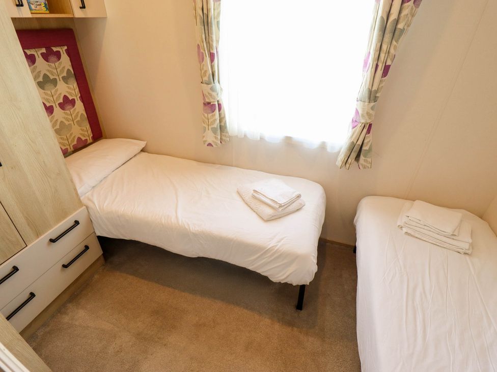 A bedroom with two single beds and cabinets at Coastfields Holiday Village Ingoldmells