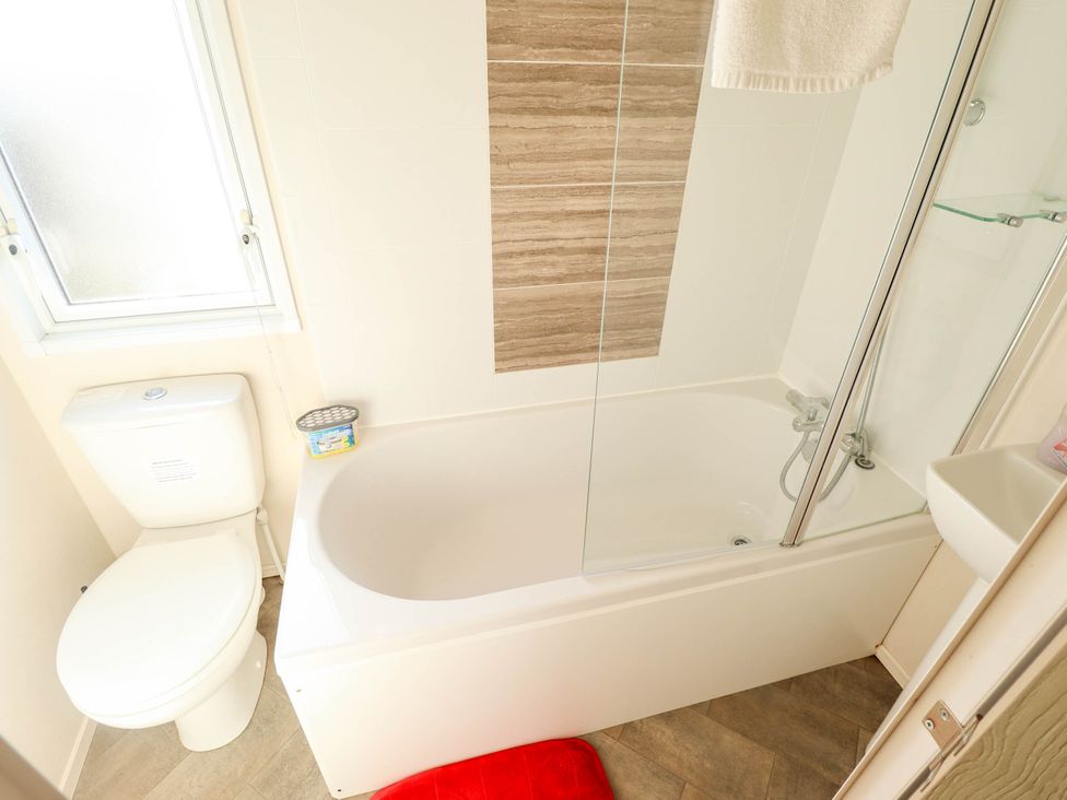 A bathroom with a shower and bathtub at Coastfields Holiday Village in Ingoldmells