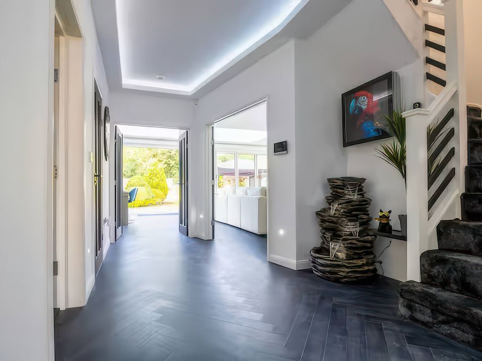 A hallway with doors and stairs at 19 Hillside Road in Northwood, Hertfordshire