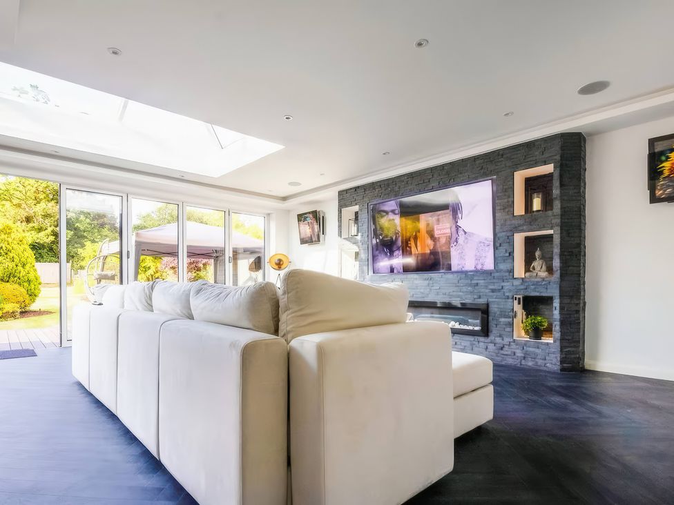 A living room with a sofa and television at 19 Hillside Road in Northwood, Hertfordshire