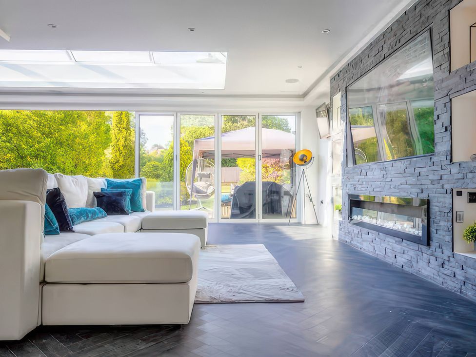 A living room with a sofa and fireplace at 19 Hillside Road Northwood, Hertfordshire