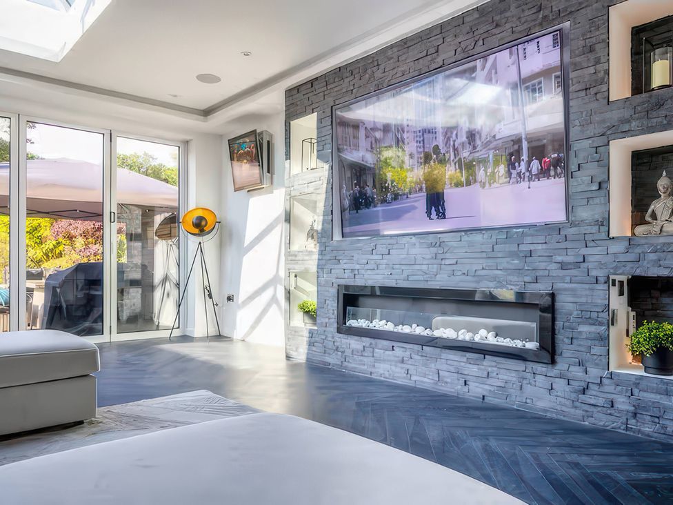 A living room with a television and fireplace at 19 Hillside Road, Northwood, Hertfordshire