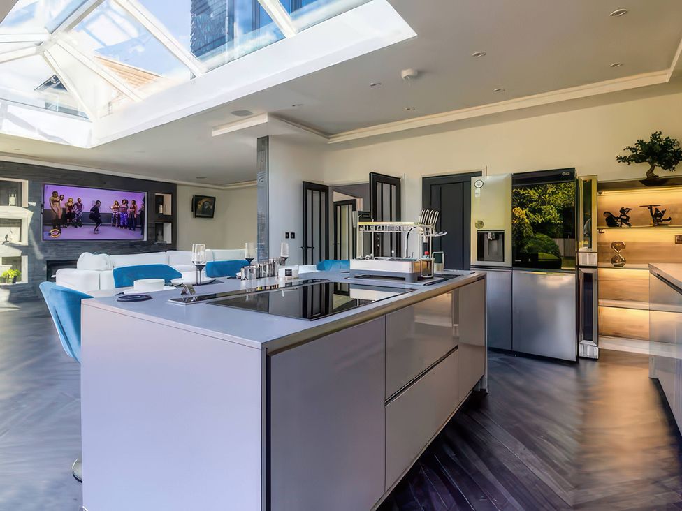 A kitchen with a large island and television at 19 Hillside Road, Northwood, Hertfordshire