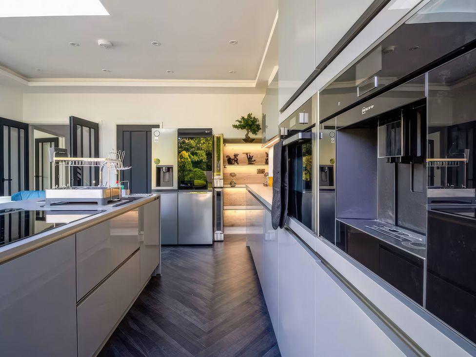 A kitchen with modern appliances and an island at 19 Hillside Road Northwood, Hertfordshire