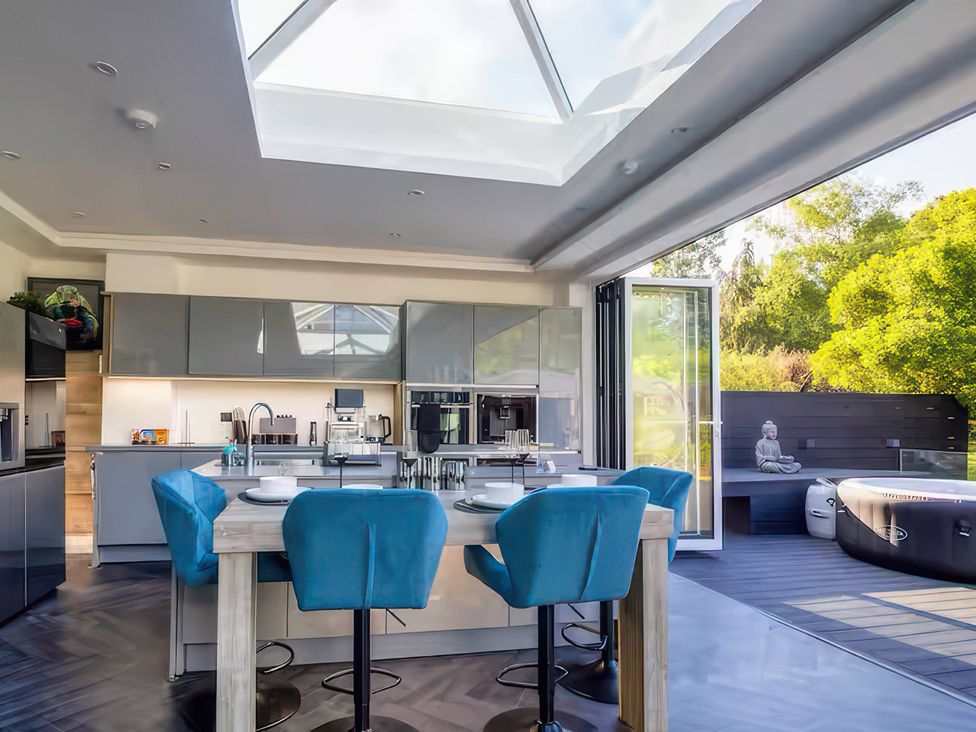 A kitchen with an island and bar stools at 19 Hillside Road in Northwood, Hertfordshire
