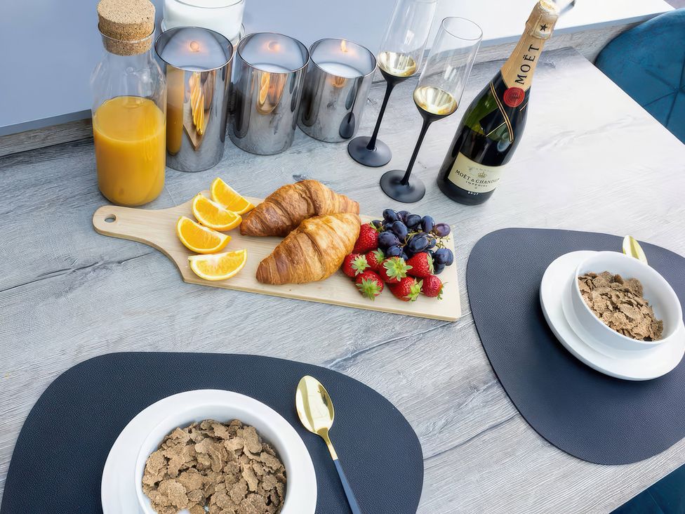 A dining table with breakfast items and drinks at 19 Hillside Road, Northwood, Hertfordshire