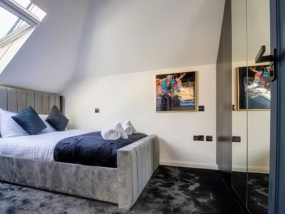 A bedroom with a bed and artwork on the wall at 19 Hillside Road, Northwood, Hertfordshire