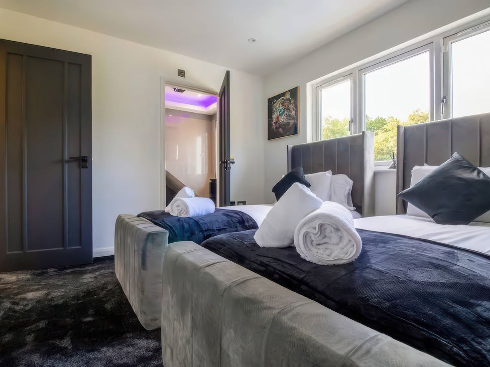A bedroom with two beds and towels at 19 Hillside Road Northwood, Hertfordshire