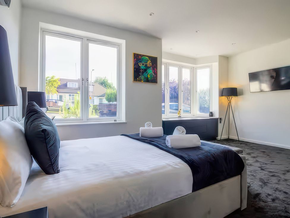 A bedroom with a bed and artwork at 19 Hillside Road Northwood, Hertfordshire