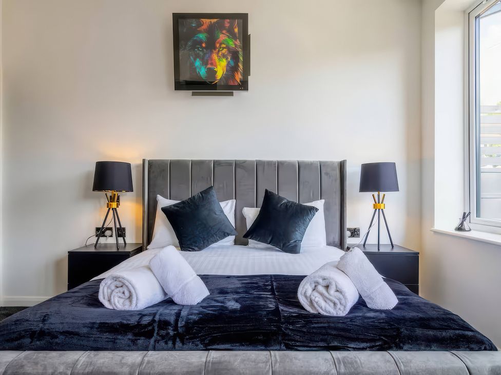 A bedroom with a bed and lamps at 19 Hillside Road Northwood, Hertfordshire
