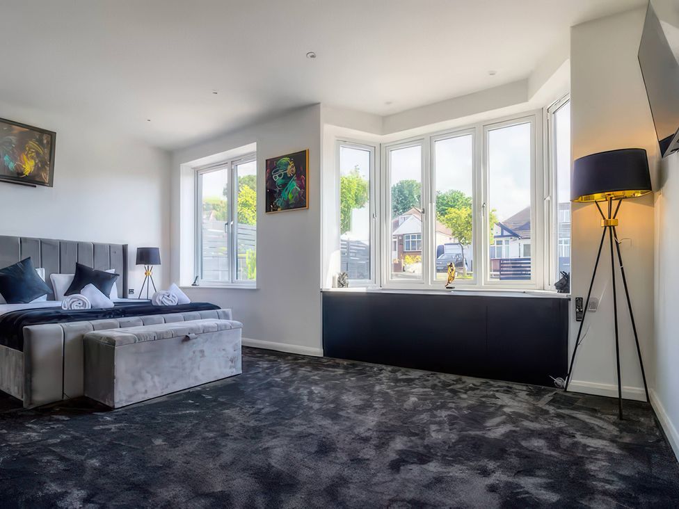 A bedroom with a bed and artwork at 19 Hillside Road in Northwood, Hertfordshire