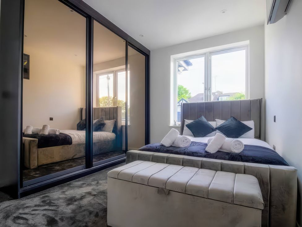 A bedroom with a bed and wardrobe at 19 Hillside Road in Northwood, Hertfordshire