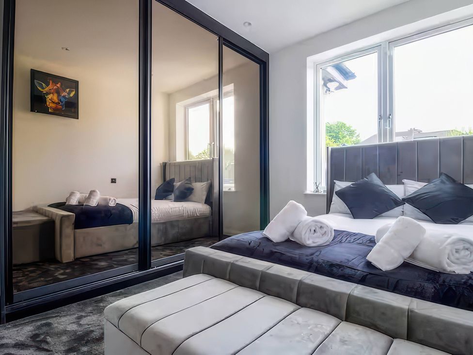 A bedroom with a bed and sofa at 19 Hillside Road Northwood, Hertfordshire