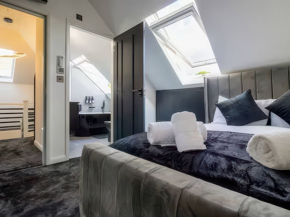 A bedroom with bed and desk at 19 Hillside Road Northwood, Hertfordshire