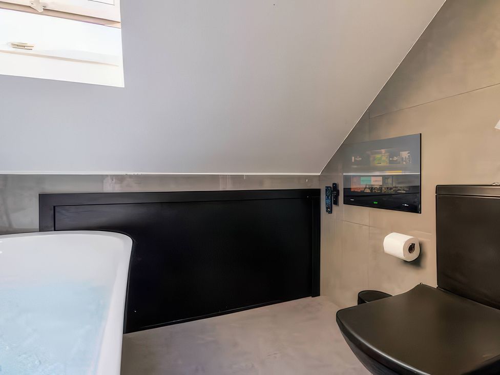 A bathroom with a bathtub and toilet at 19 Hillside Road Northwood, Hertfordshire