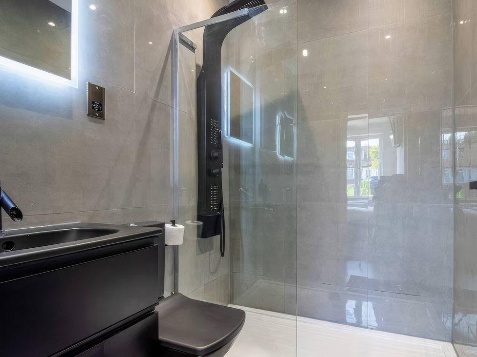A bathroom with a shower and toilet at 19 Hillside Road Northwood, Hertfordshire