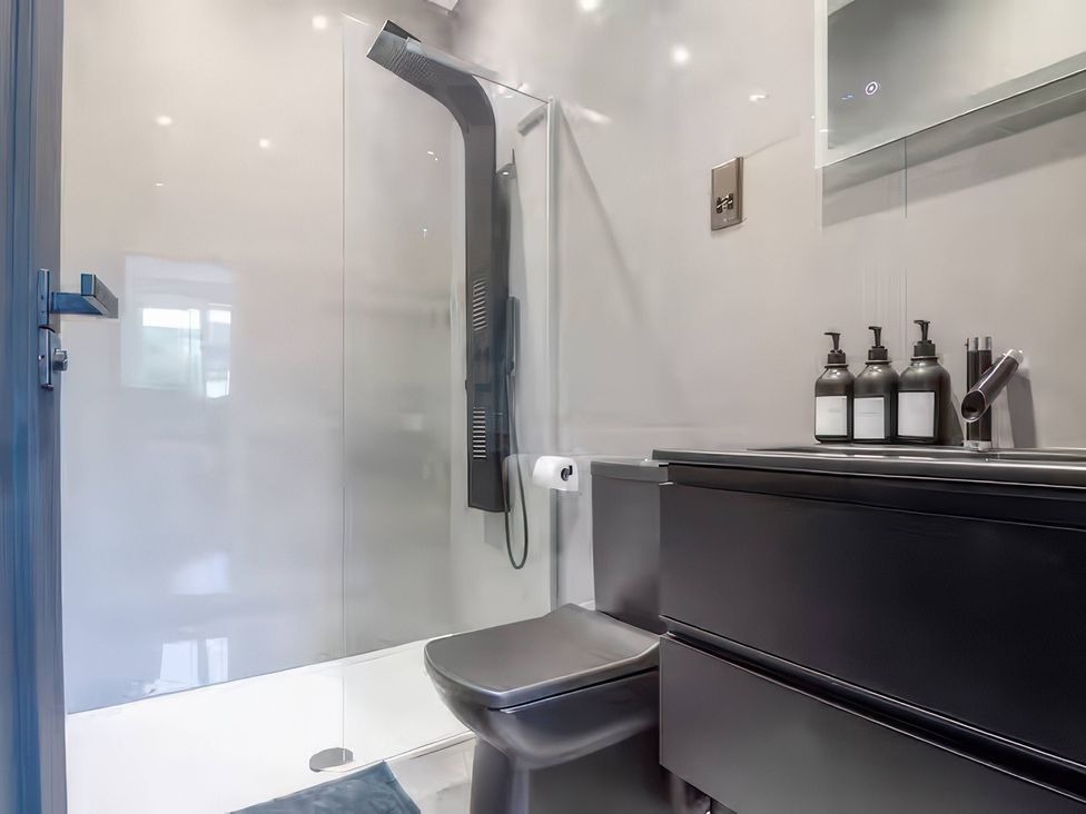 A bathroom with a shower and toilet at 19 Hillside Road in Northwood, Hertfordshire