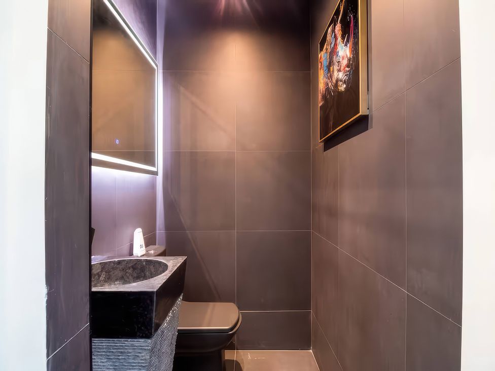 A bathroom with a toilet and sink at 19 Hillside Road Northwood Hertfordshire
