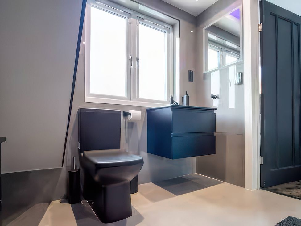 A bathroom with a toilet and sink at 19 Hillside Road, Northwood, Hertfordshire