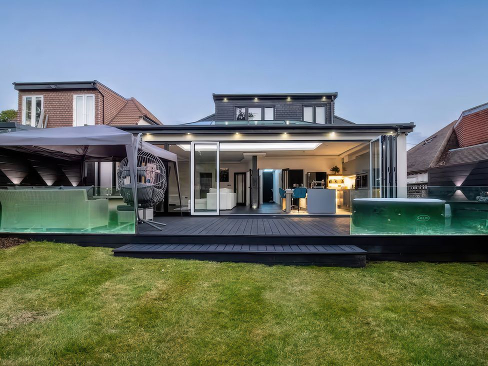 An outdoor area with a deck and hot tub at 19 Hillside Road, Northwood, Hertfordshire