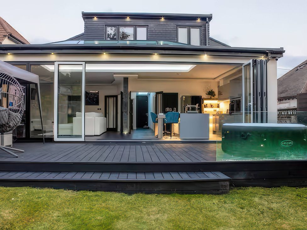 An outdoor area with a hot tub and kitchen at 19 Hillside Road in Northwood, Hertfordshire