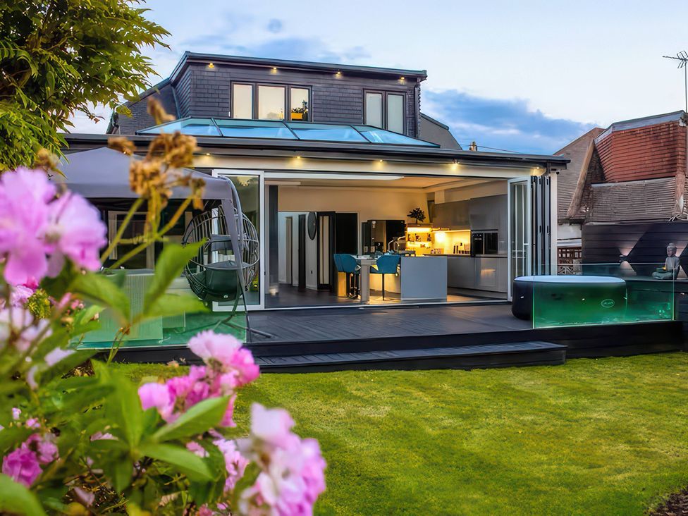 A garden with a house and kitchen view at 19 Hillside Road in Northwood Hertfordshire