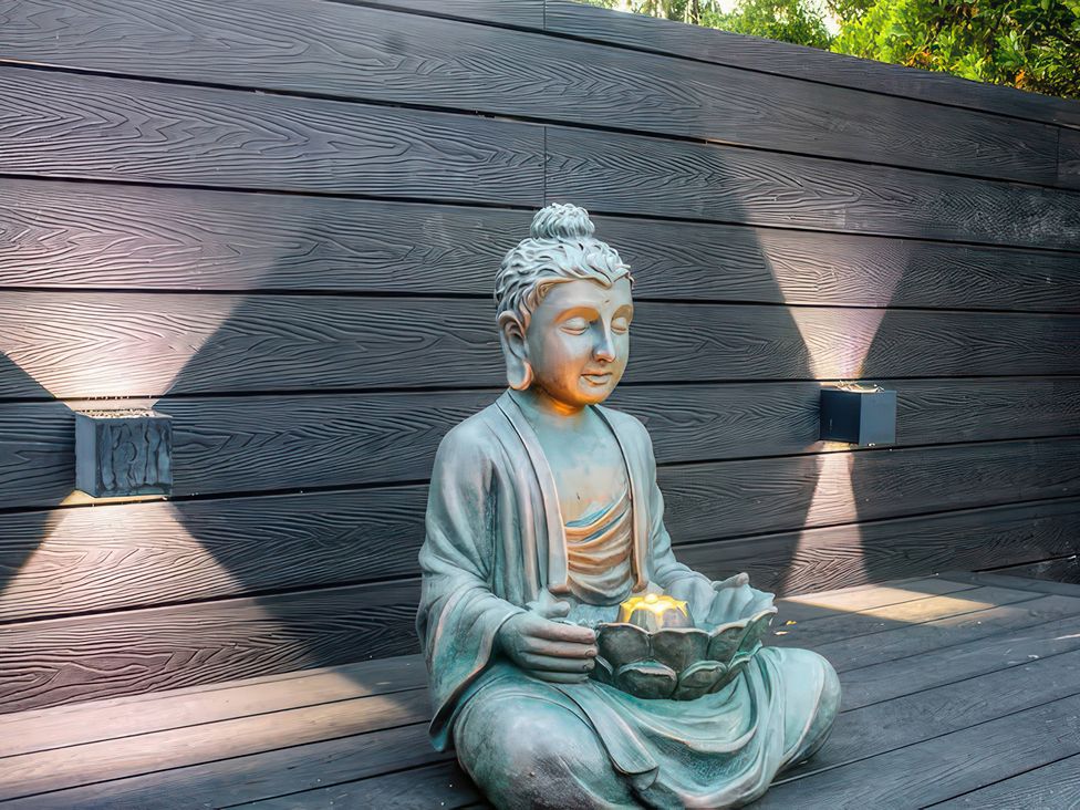 A Buddha statue holding a lotus flower at 19 Hillside Road Northwood, Hertfordshire