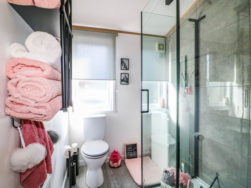 A bathroom with a shower and towels at Patos y Nosotros Grantham