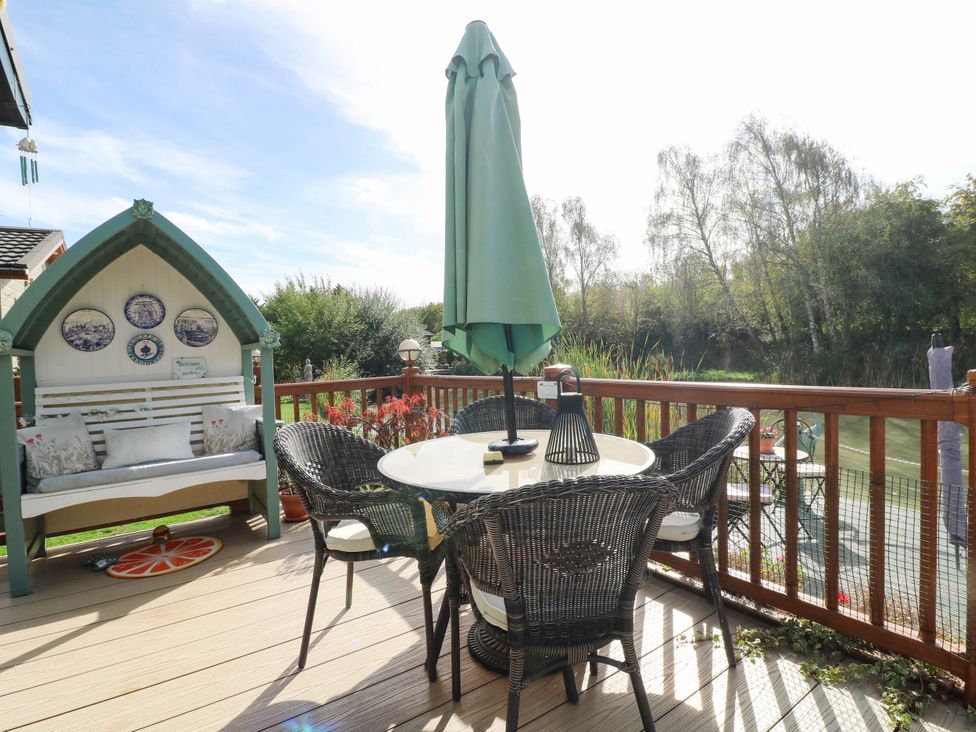 An outdoor space with a table and chairs near the river at Patos y Nosotros in Grantham