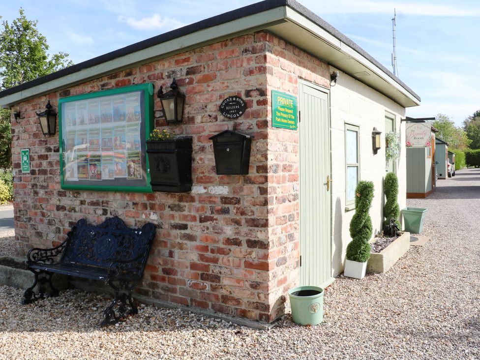 An outdoor area with a brick building and bench at Patos y Nosotros Grantham