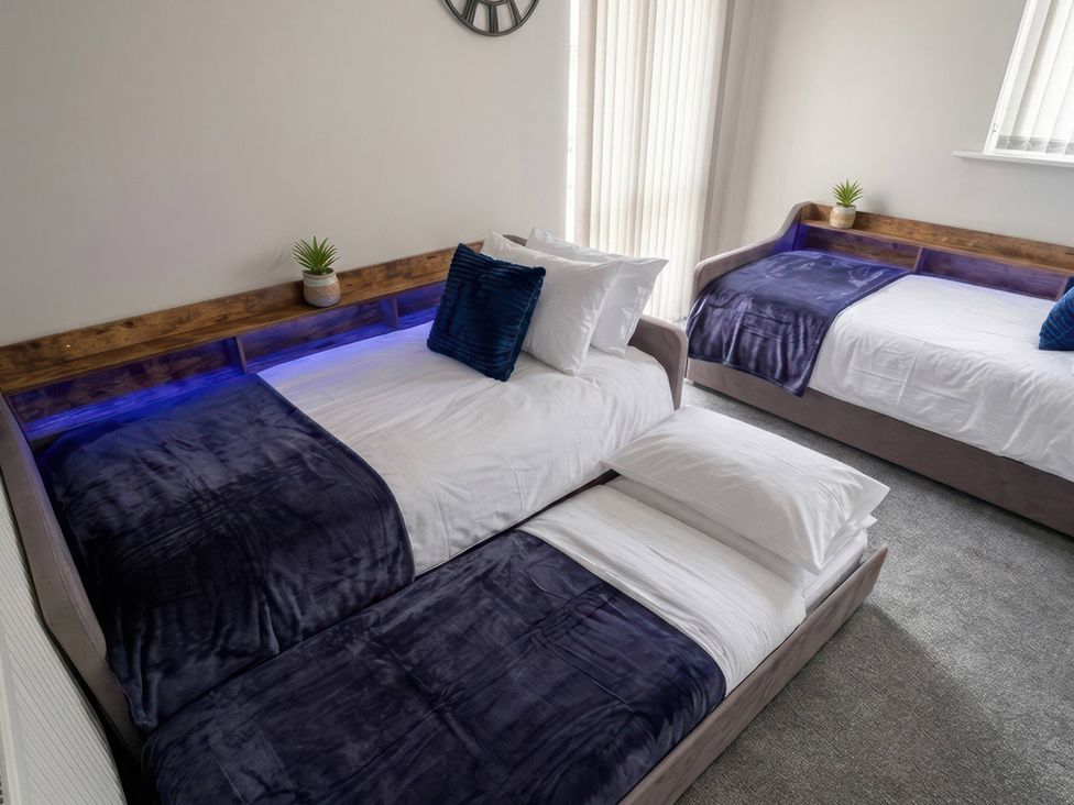 A bedroom with two beds and a plant at Flat 3 Brown Lodge in Sheerness