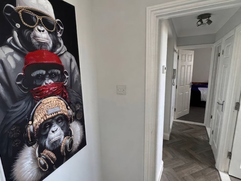 A hallway with wall art of monkeys at Flat 3 Brown Lodge in Sheerness