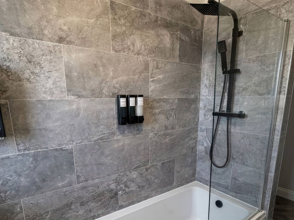 A bathroom with a shower and bathing products at Flat 3 Brown Lodge in Sheerness