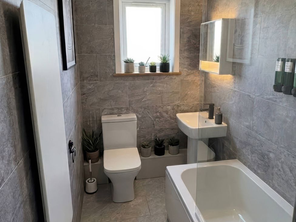 A bathroom with a toilet, sink, and bathtub at Flat 3 Brown Lodge in Sheerness