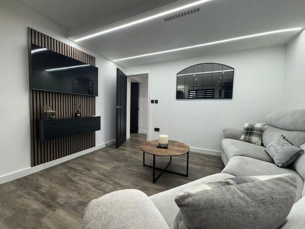 A living room with a sofa and television at Flat 1 Hilltop Court in Uxbridge
