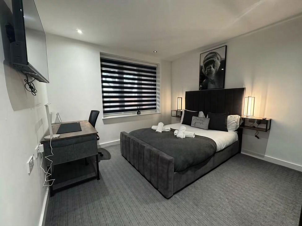 A bedroom with a bed, desk, and TV at Flat 1 Hilltop Court Uxbridge