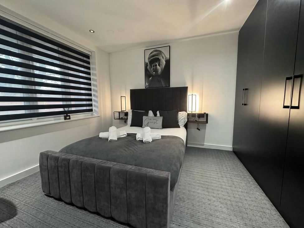 A bedroom with a bed and wardrobe at Flat 1 Hilltop Court in Uxbridge